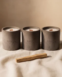 Tři betonové svíčky Lucera na lněné látce vedle dřívka palo santo